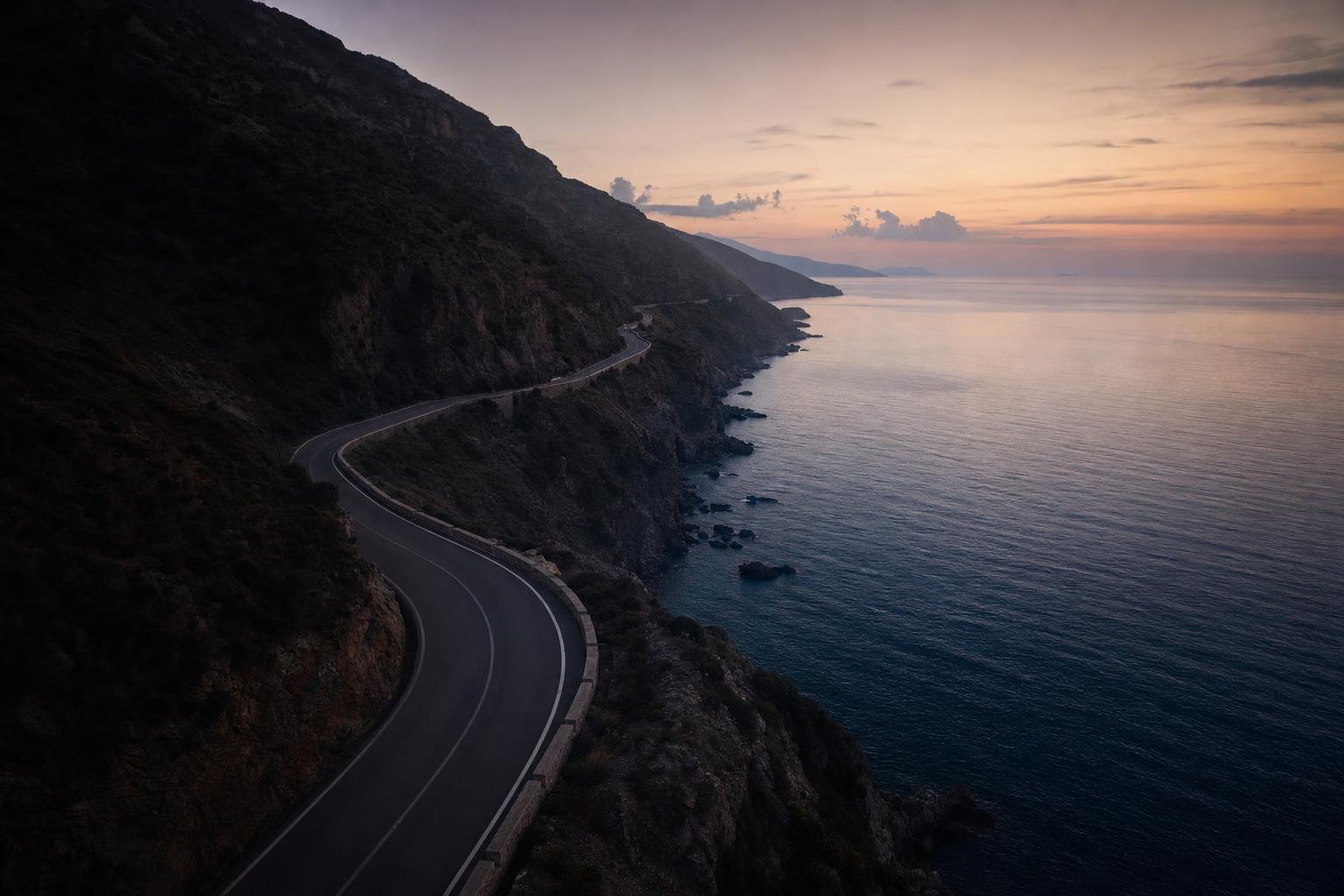 Winding coastal road seen from above at dusk